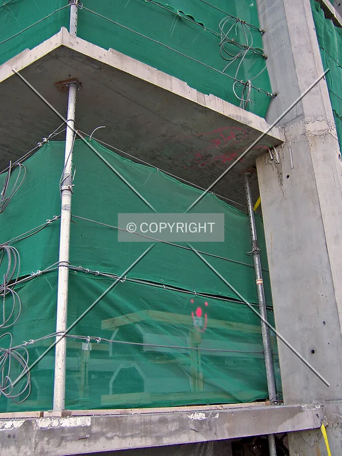 Northeast corner at the Roosevelt Road elevation. Cladding material sits stacked within the building, just beyond the windscreen