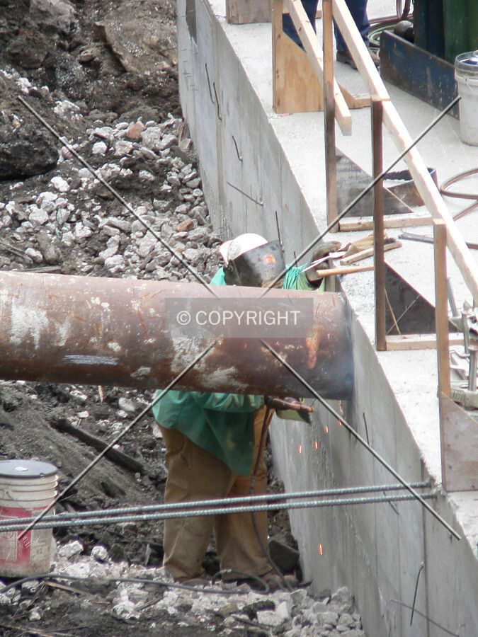An ironworker working on a tieback and concrete mat connection