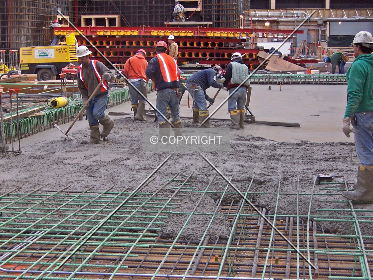 Workers pouring concrete for the ground floor slab on the west side of the site