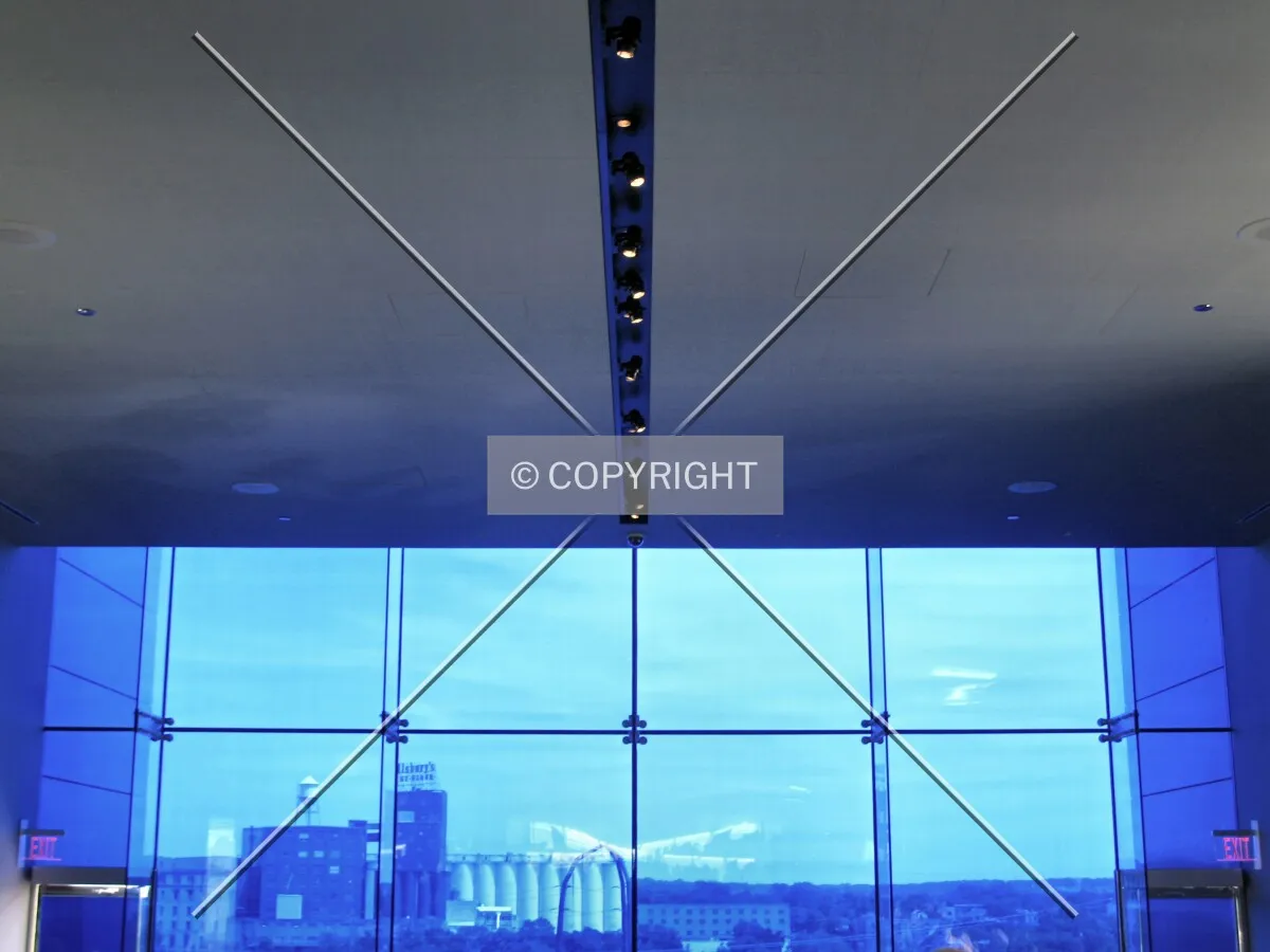 Blue glass contrasts with the muted ceiling on the Endless Bridge; Pillsbury A Mill visible across the Mississippi River