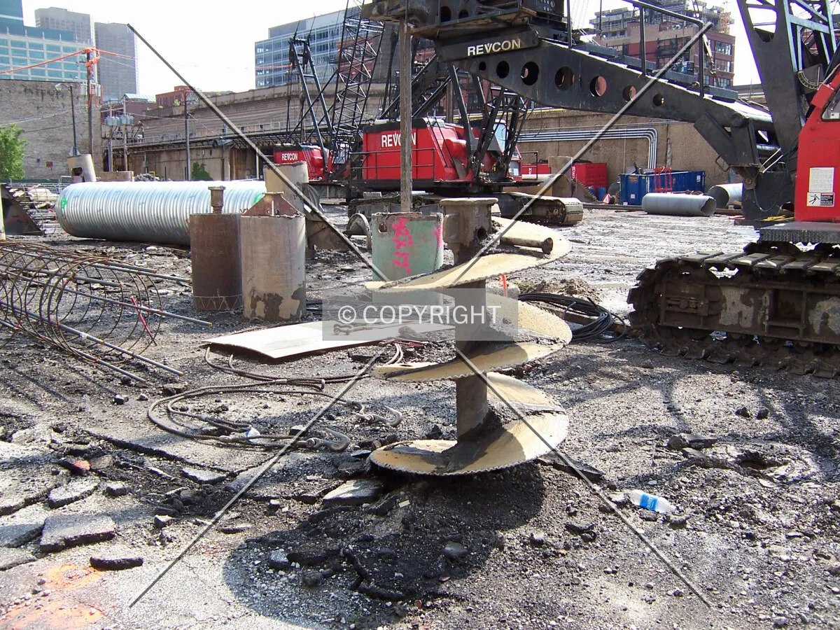 Looking southwest, with caisson drilling cranes and various drilling tools scattered across the site
