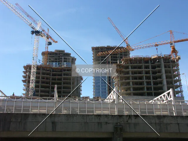 The entire complex under construction with viaduct and SkyTrain station in foreground