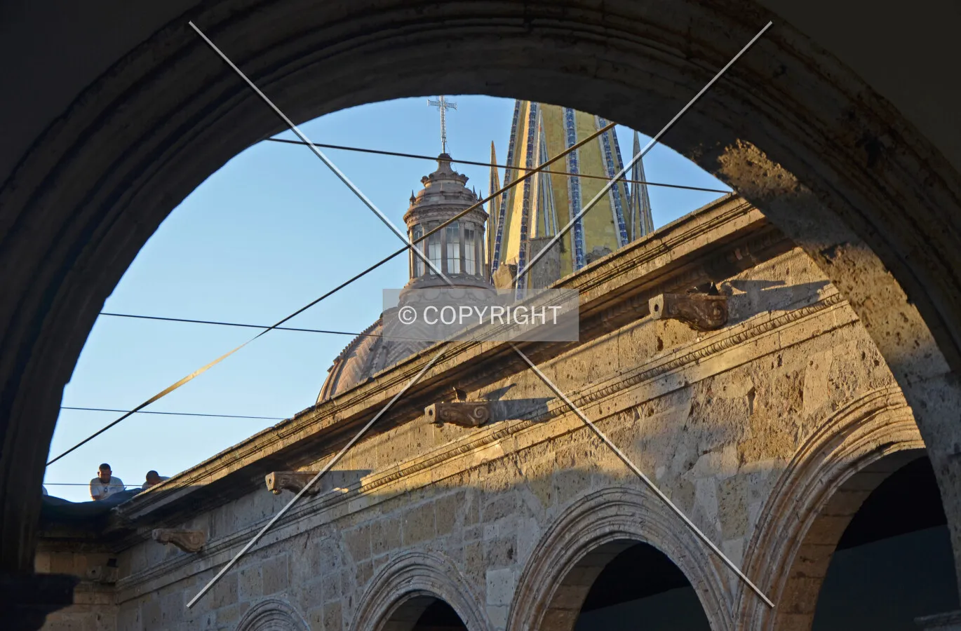 Courtyard wall detail with the spires of the neighboring cathedral rising beyond.
