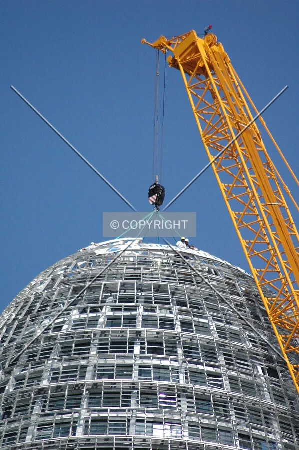 Workers placing the top of the facade