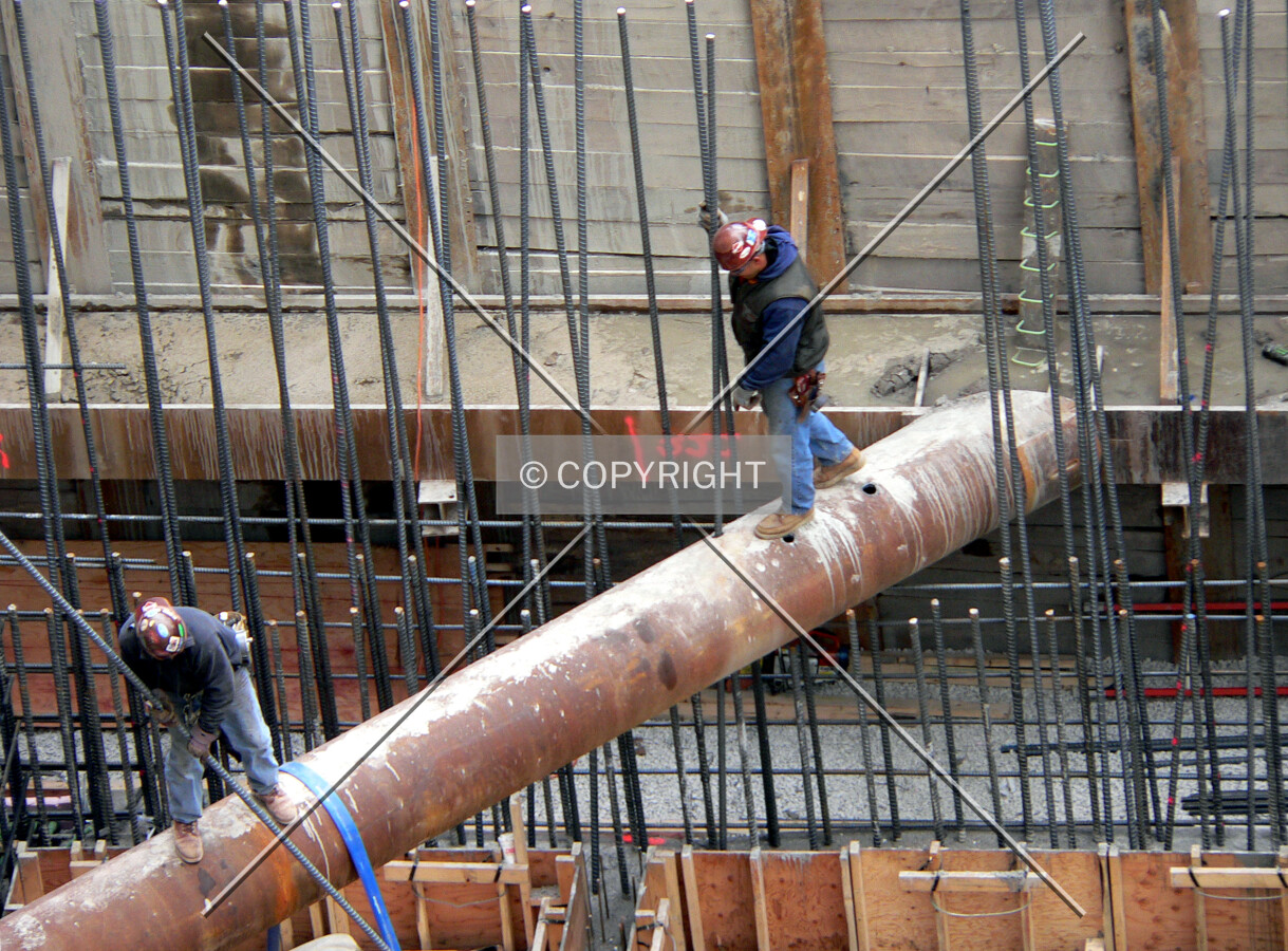 Workers removing one of the raker beams