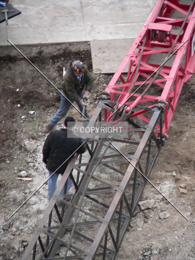 Using a sledgehammer to connect sections of a crane boom