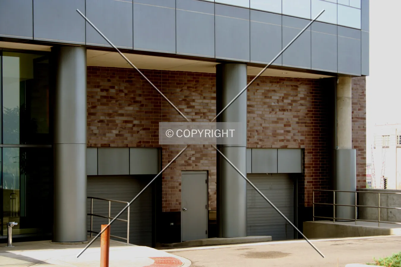 Vehicle entrances on the south side, with one column still missing its cladding