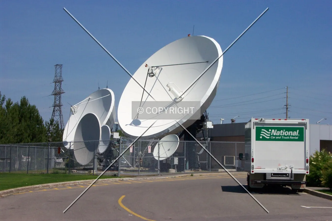 The satellite dishes located in an enclosed area to the north of the building