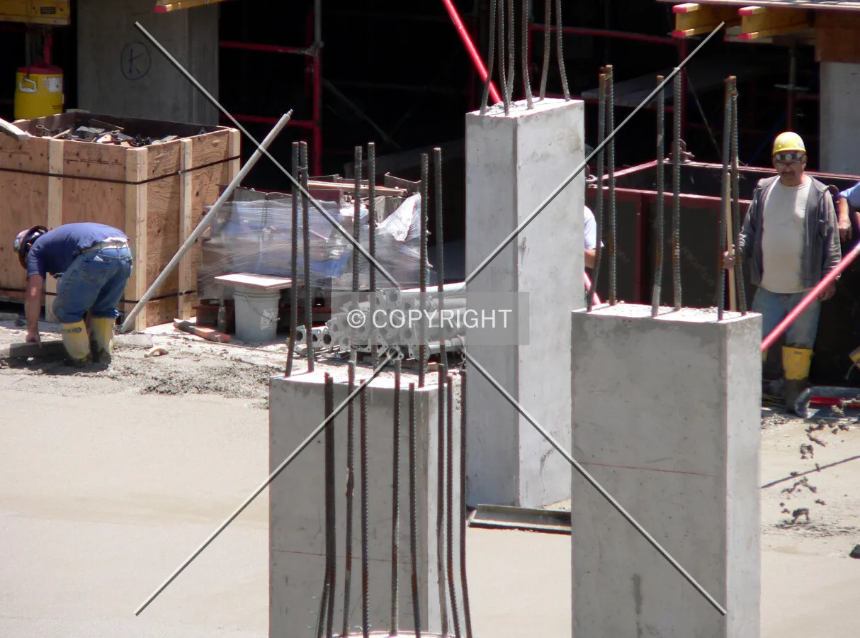 Columns visible while workers smooth concrete