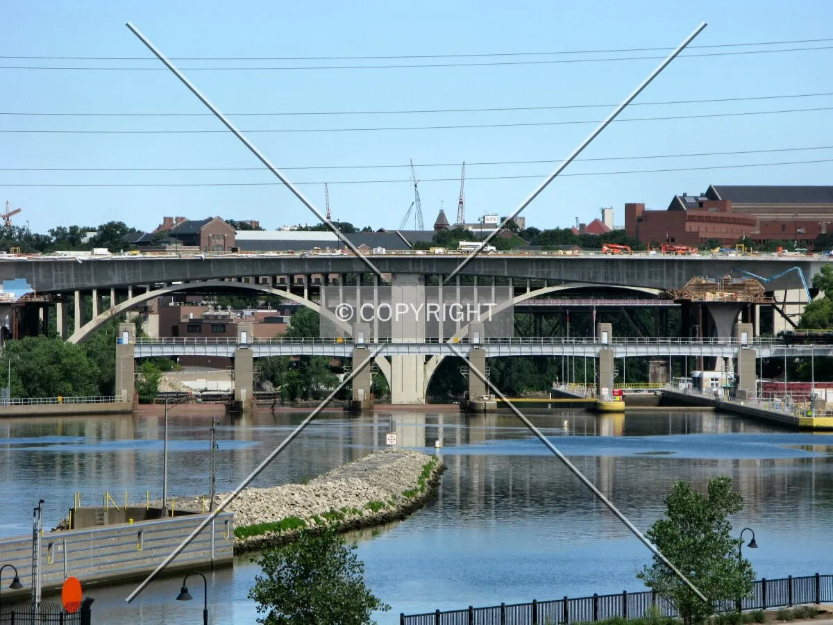 Distant view down the Mississippi River, beyond the Lower St. Anthony Locks and in front of the arches of the 10th Avenue Bridge