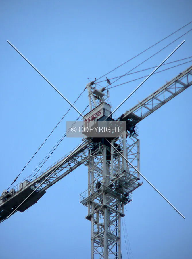 Workers receiving a section of tower for the crane