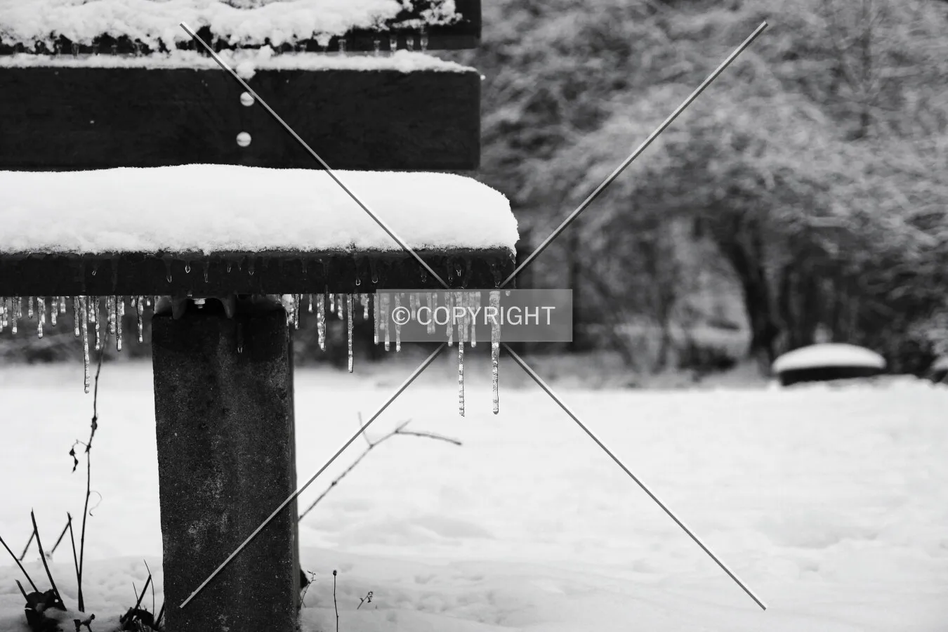 park bench in winter with icicles on it