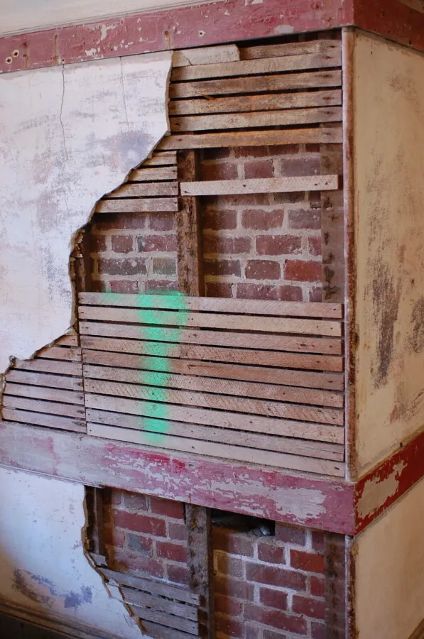 Plaster, lath, and brick of an interior wall