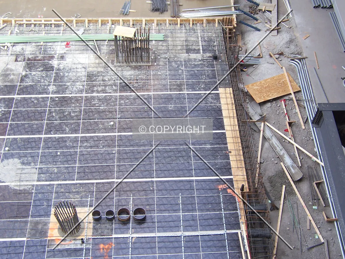 Looking down at the south edge of the site. Temporary decking and pipe sleaves are in place for the pouring of the concrete slab