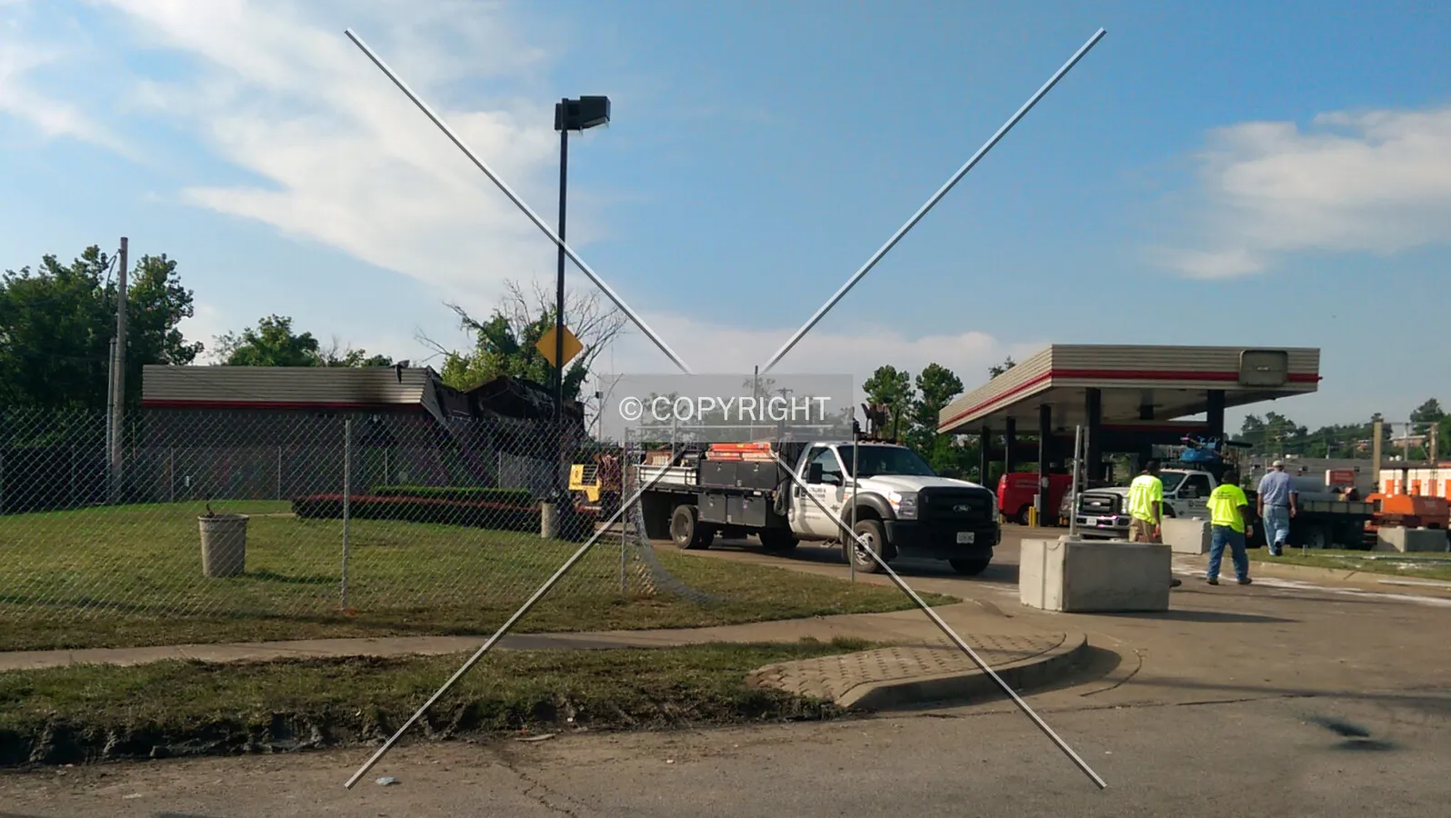 View from the north while workers construct a fence around the property; August 19, 2014