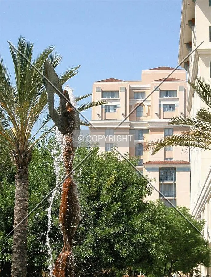 The top floors of the hotel with fountain and palms of Plaza Las Fuentes