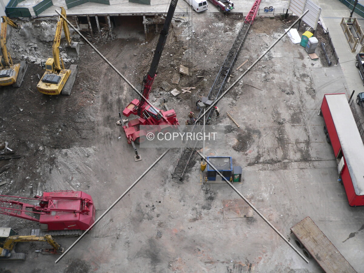 View of the site as workers assemble a crane