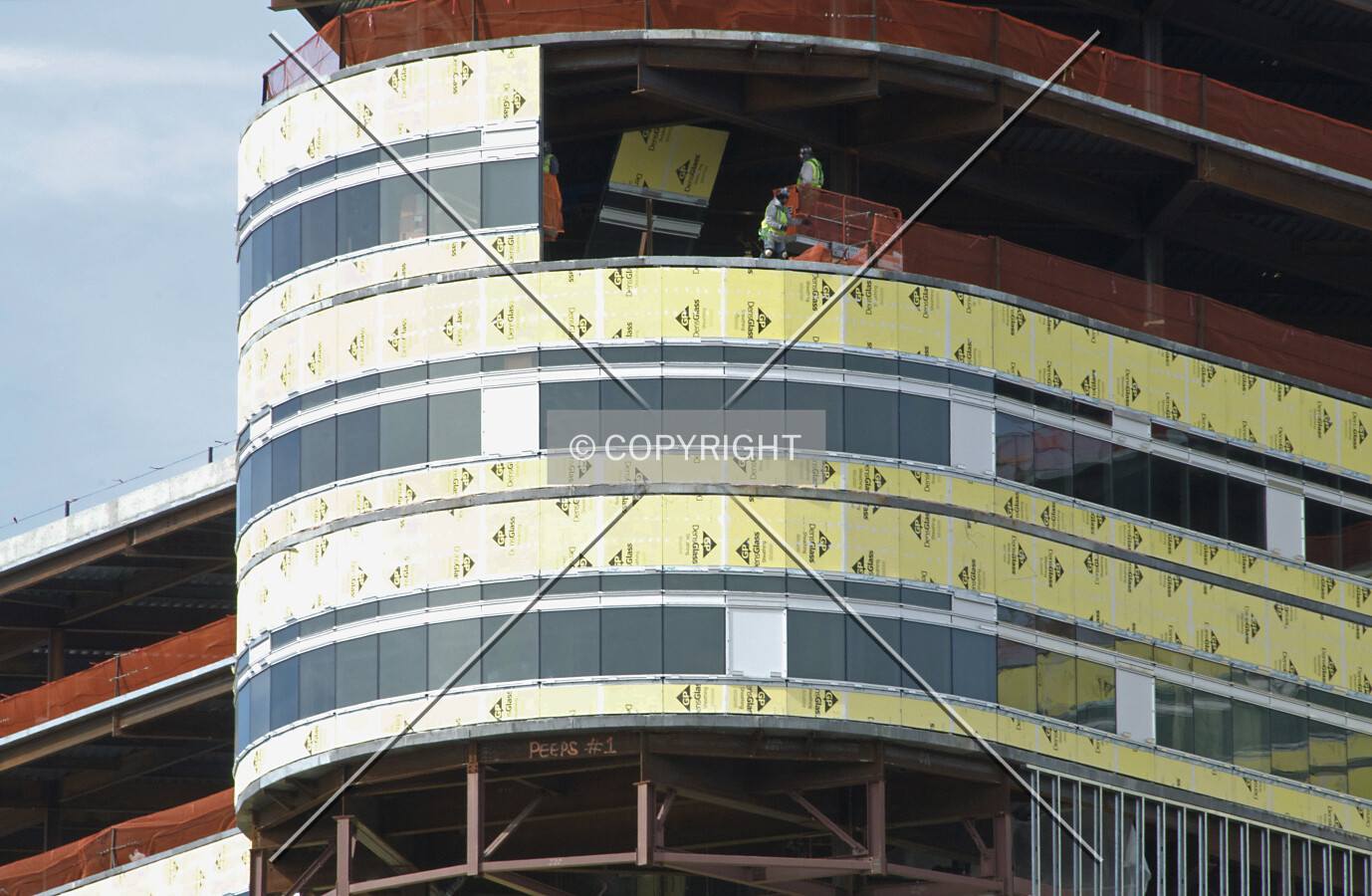 Workers installing a section of facade insulation and glass on the southeast lobe, viewed from the east