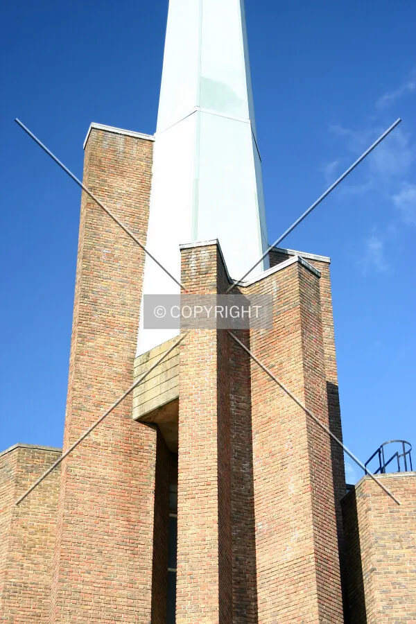 View southwest of the top of the brick tower and base of the spire from Clifton Gardens