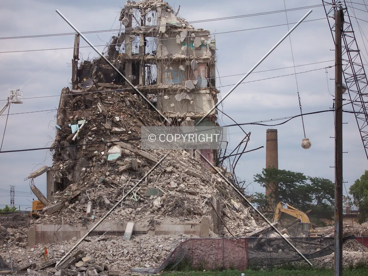 Demolition view from the south, as a wrecking ball swings into the eastern facade