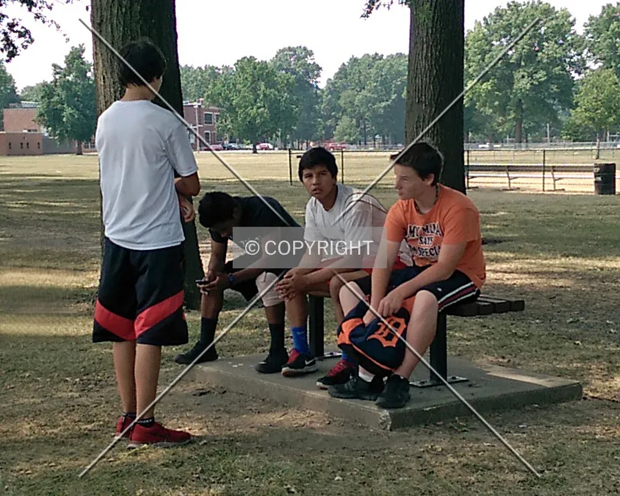 Teenagers resting on a park bench; August 4, 2014