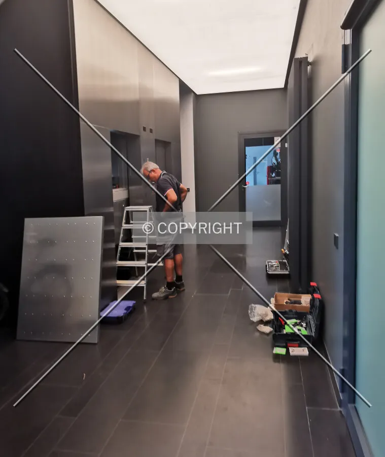 Workers performing elevator maintenance