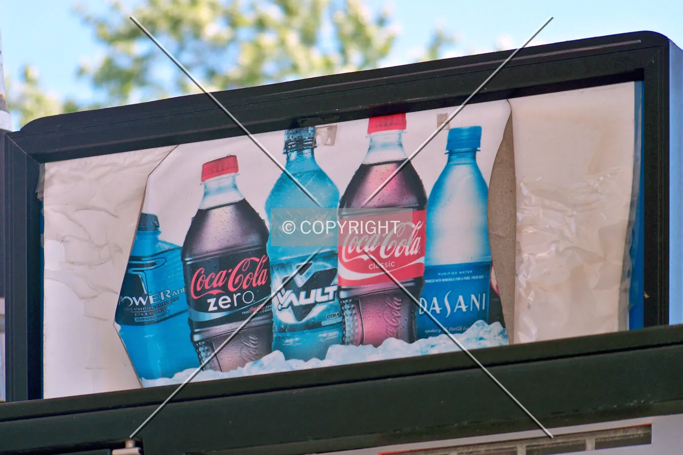 A weathered beverage advertisement above one of the fuel pumps