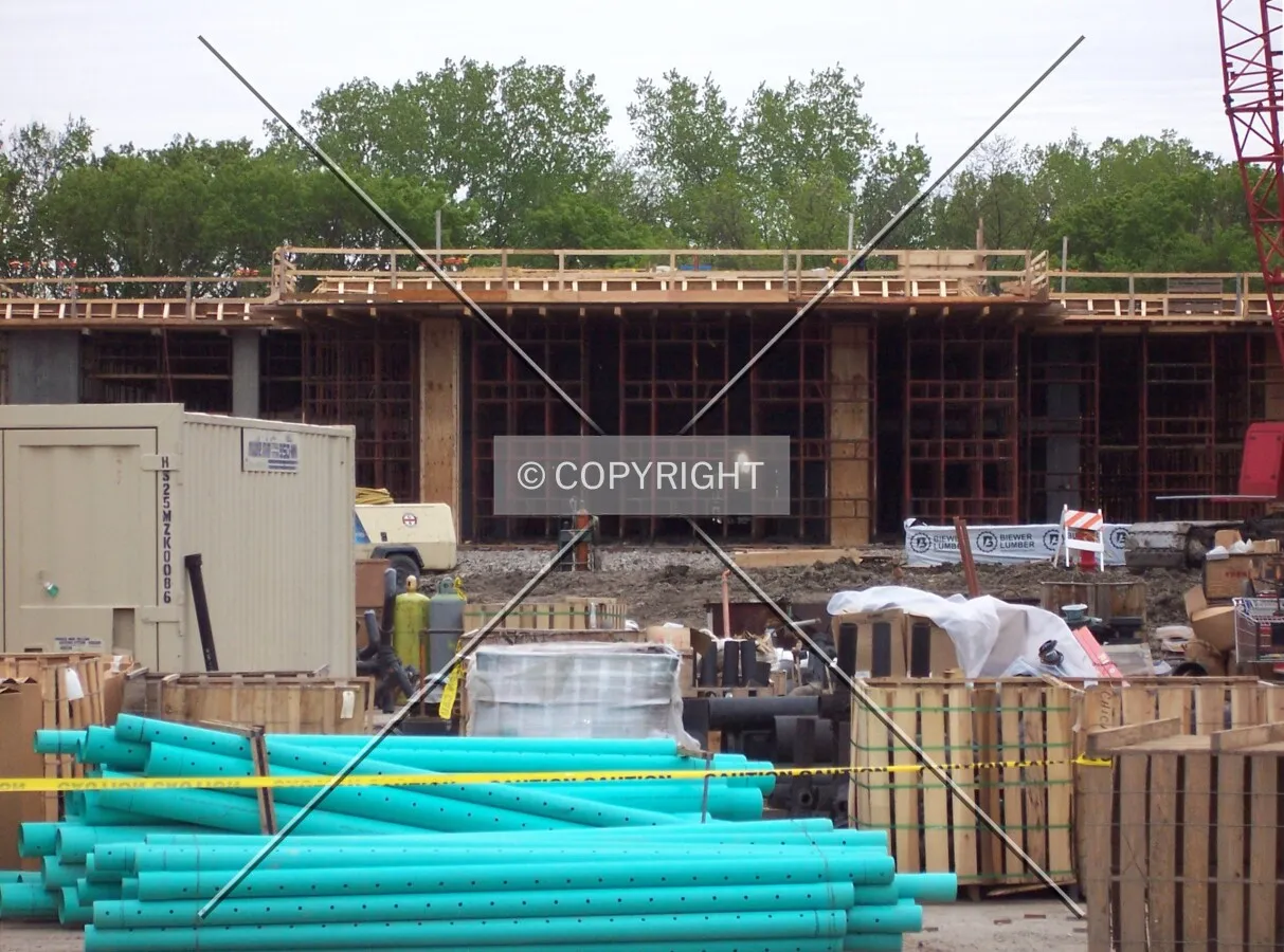 PVC piping and other construction materials in front of the Oak Tower