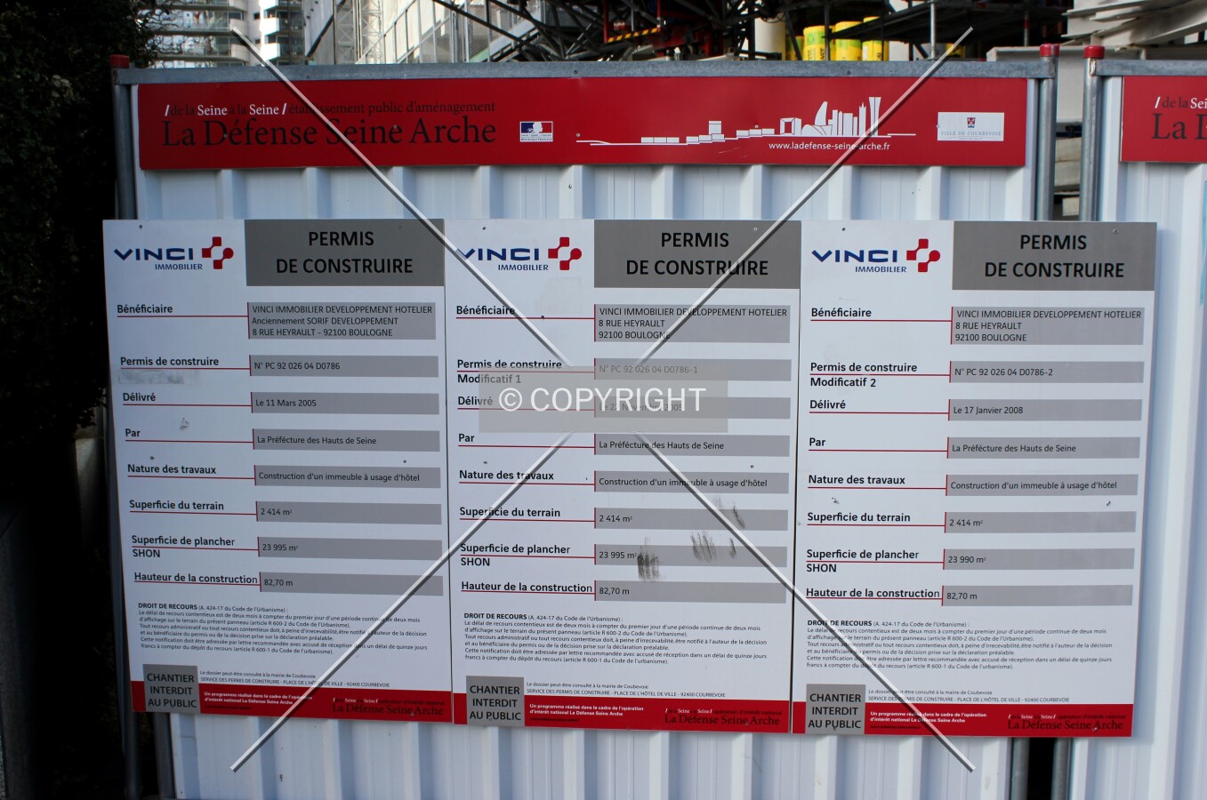 The building permits displayed at the construction site.