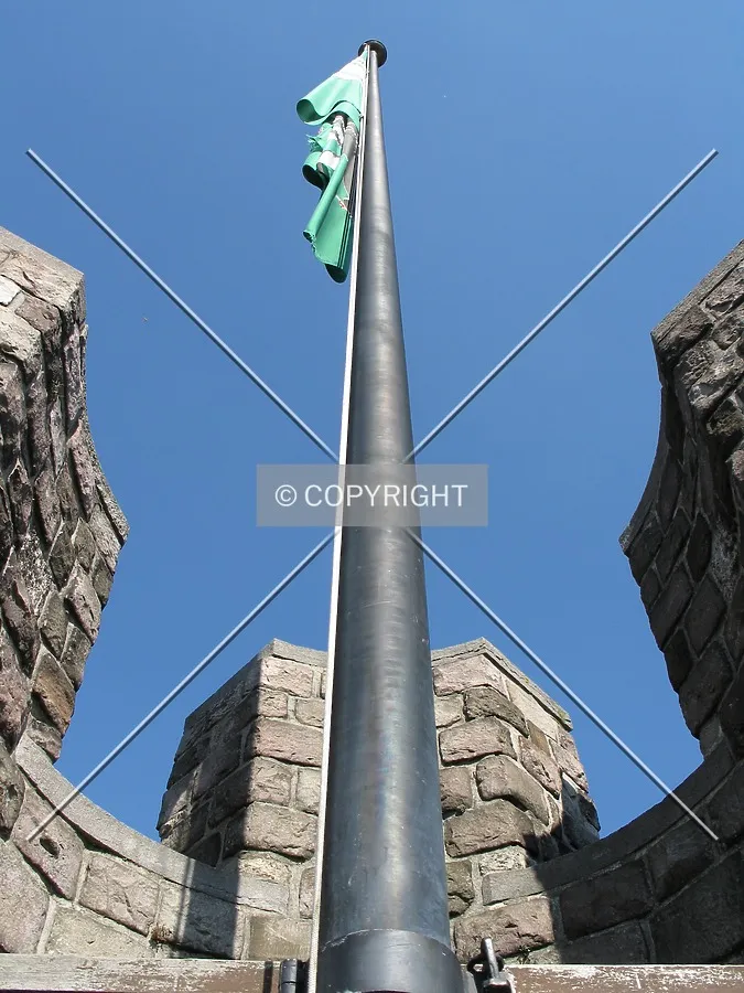 Looking up to a banner mounted on the crenelations of the main tower