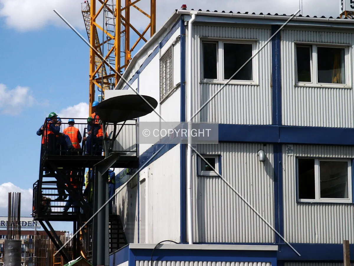 Workers on the stairway by the trailer complex