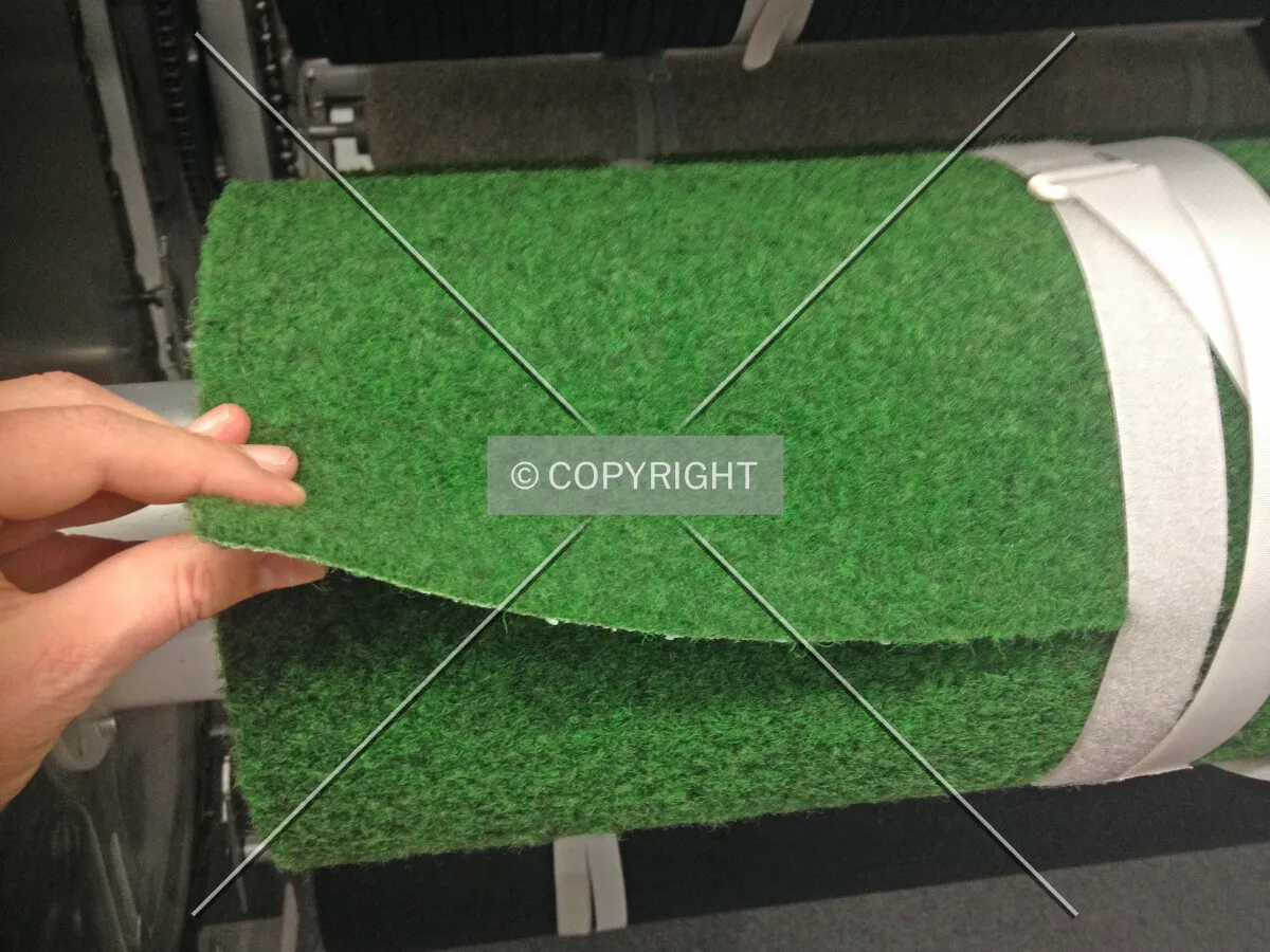 A person is evaluating a green carpet