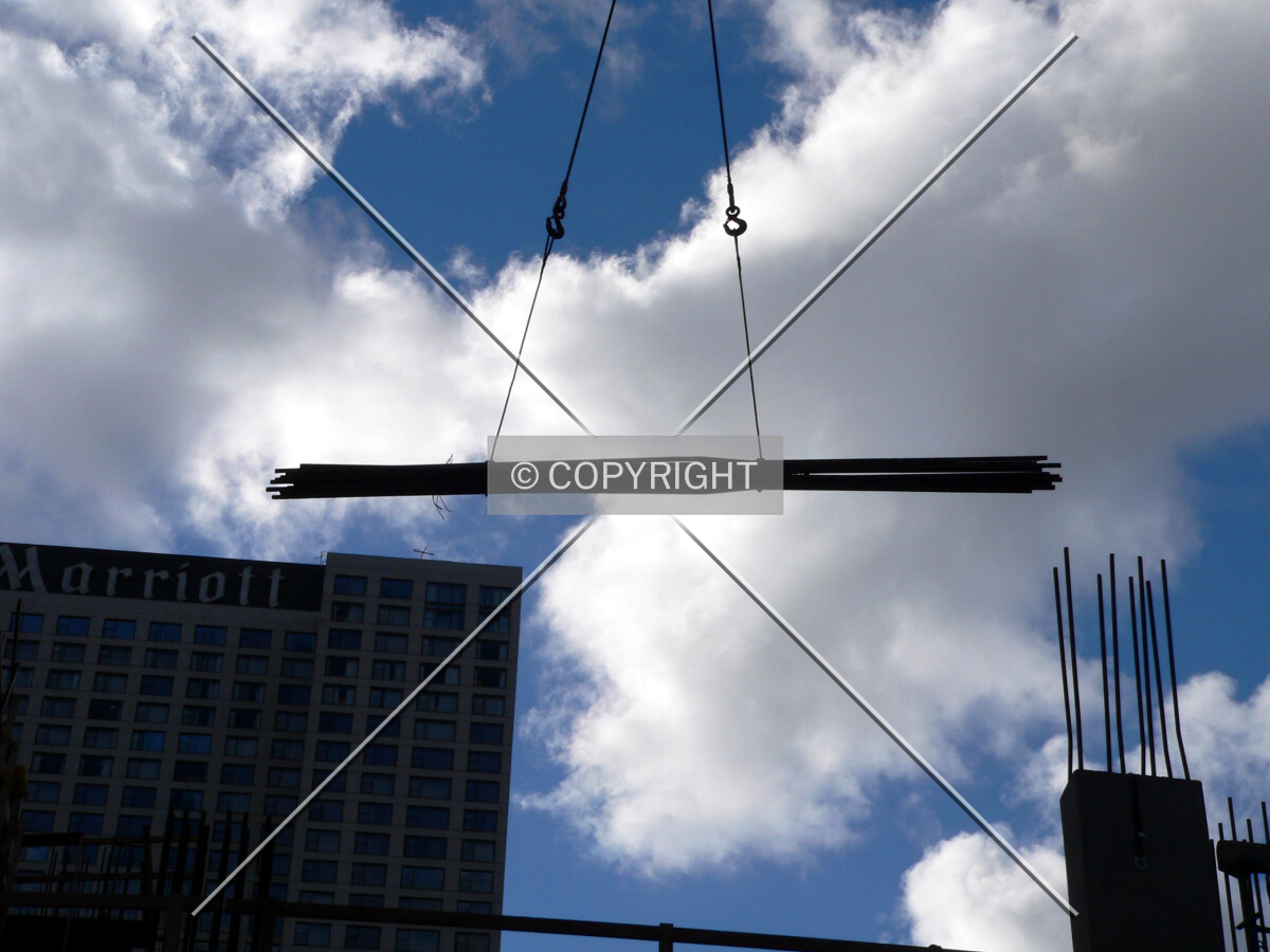Tower crane relocating a bundle of rebar